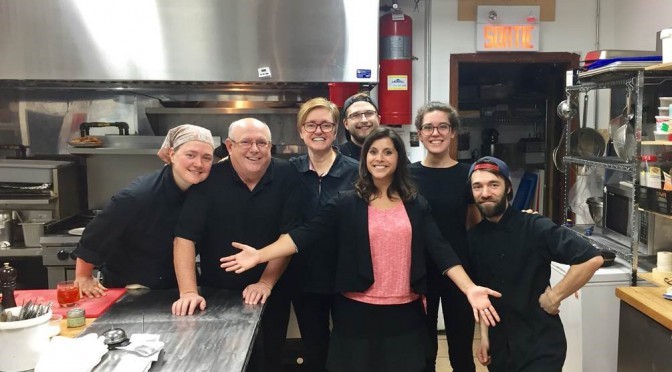 a group of chefs proudly standing in a kitchen