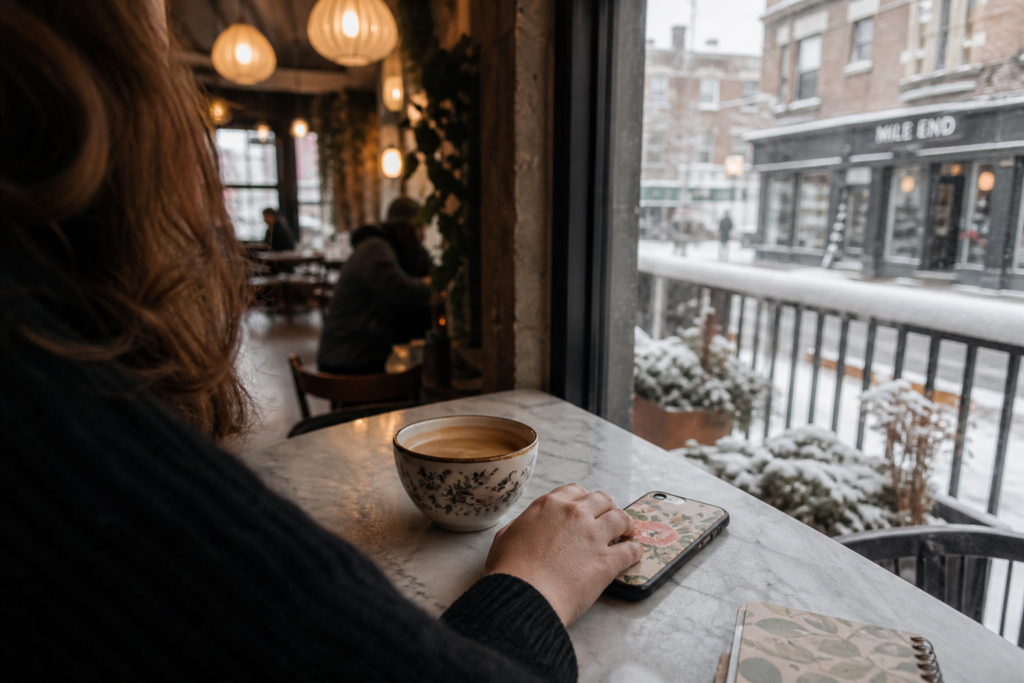 Person enjoys coffee at cozy cafe by snowy window - Montreal Styles