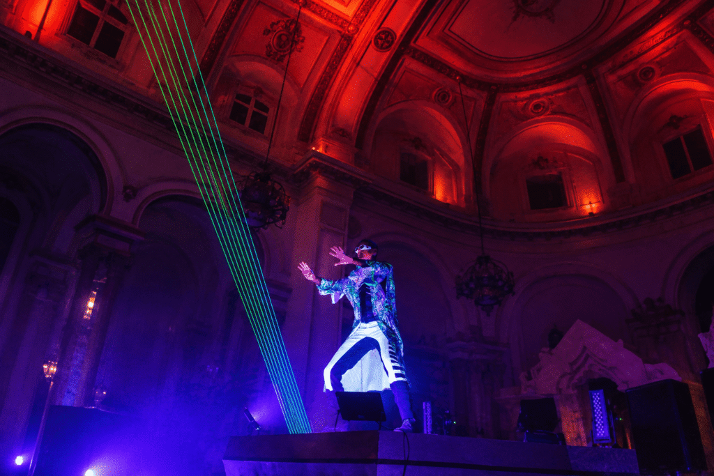 Performer surrounded by dramatic laser effects.